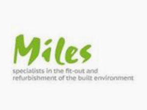 The image features a logo with the text "Miles" written in green, stylized font. Below, there is smaller grey text that reads "specialists in the fit-out and refurbishment of the built environment." The background is white, indicating it's part of Miles Partitioning Industries Limited from Bromsgrove, Worcestershire.