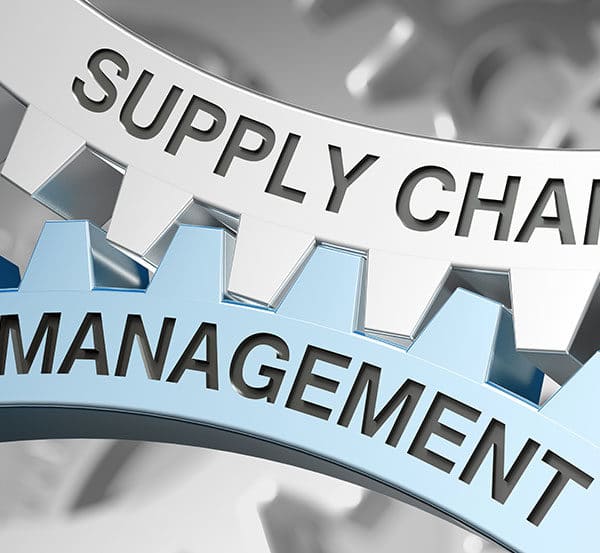 Close-up of two interlocking gears. The top gear is labeled "SUPPLY CHAIN" and the bottom gear is labeled "MANAGEMENT." The metallic shades emphasize the connection and integration of supply chain, supplier management, and overall management processes.