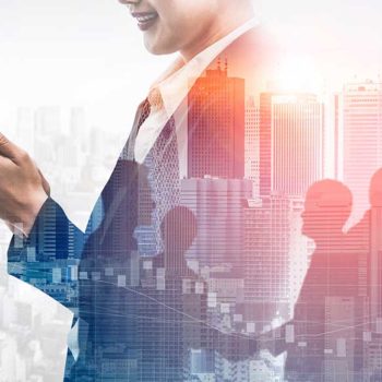 A business professional in a suit holds a smartphone, smiling while looking at the screen. The background features a double exposure of a city skyline and silhouettes of people walking. The image conveys a dynamic, connected urban environment where utilities and vendor databases drive efficiency.