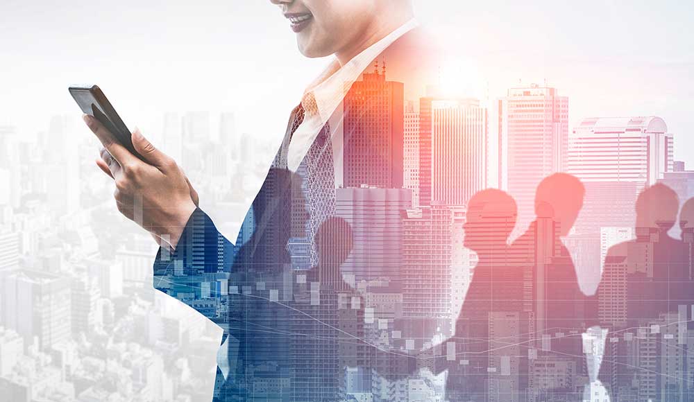 A business professional in a suit holds a smartphone, smiling while looking at the screen. The background features a double exposure of a city skyline and silhouettes of people walking. The image conveys a dynamic, connected urban environment where utilities and vendor databases drive efficiency.