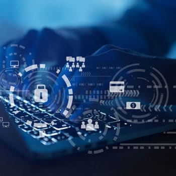 A person types on a laptop keyboard, with semi-transparent digital icons overlaying the image. Icons represent cybersecurity elements such as locks, payment cards, network connections, user profiles, and cloud storage, suggesting data protection and defense against cybersecurity threats.