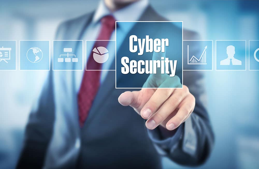 A person in a suit and tie is pressing a button labeled "Cybersecurity" on a transparent digital interface. Various icons, such as a globe, pie chart, and bar graph, are displayed in the background. The setting is modern and professional, highlighting the importance of certification in this field.