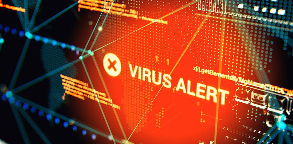 A graphical representation shows a red "VIRUS ALERT" warning with a white 'X' icon on a digital screen. Technological patterns and lines in blue and yellow tones are visible in the background, emphasizing the concept of cybersecurity threats and various types of Cyber Attacks.
