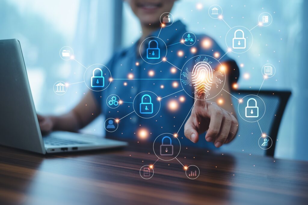A person uses a laptop, interacting with a digital display of security icons, including locks and a fingerprint. This visual embodies digital security and connectivity, enhanced by the glowing lines linking the icons—a vital step for those aiming to become SSIP accredited.