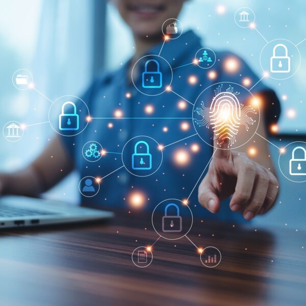 A person uses a laptop, interacting with a digital display of security icons, including locks and a fingerprint. This visual embodies digital security and connectivity, enhanced by the glowing lines linking the icons—a vital step for those aiming to become SSIP accredited.